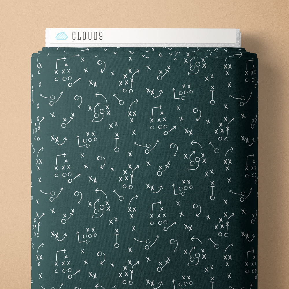 Pattern of football play diagrams on a dark green fabric