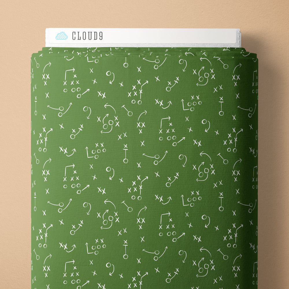 Football play diagrams and symbols on a green fabric background