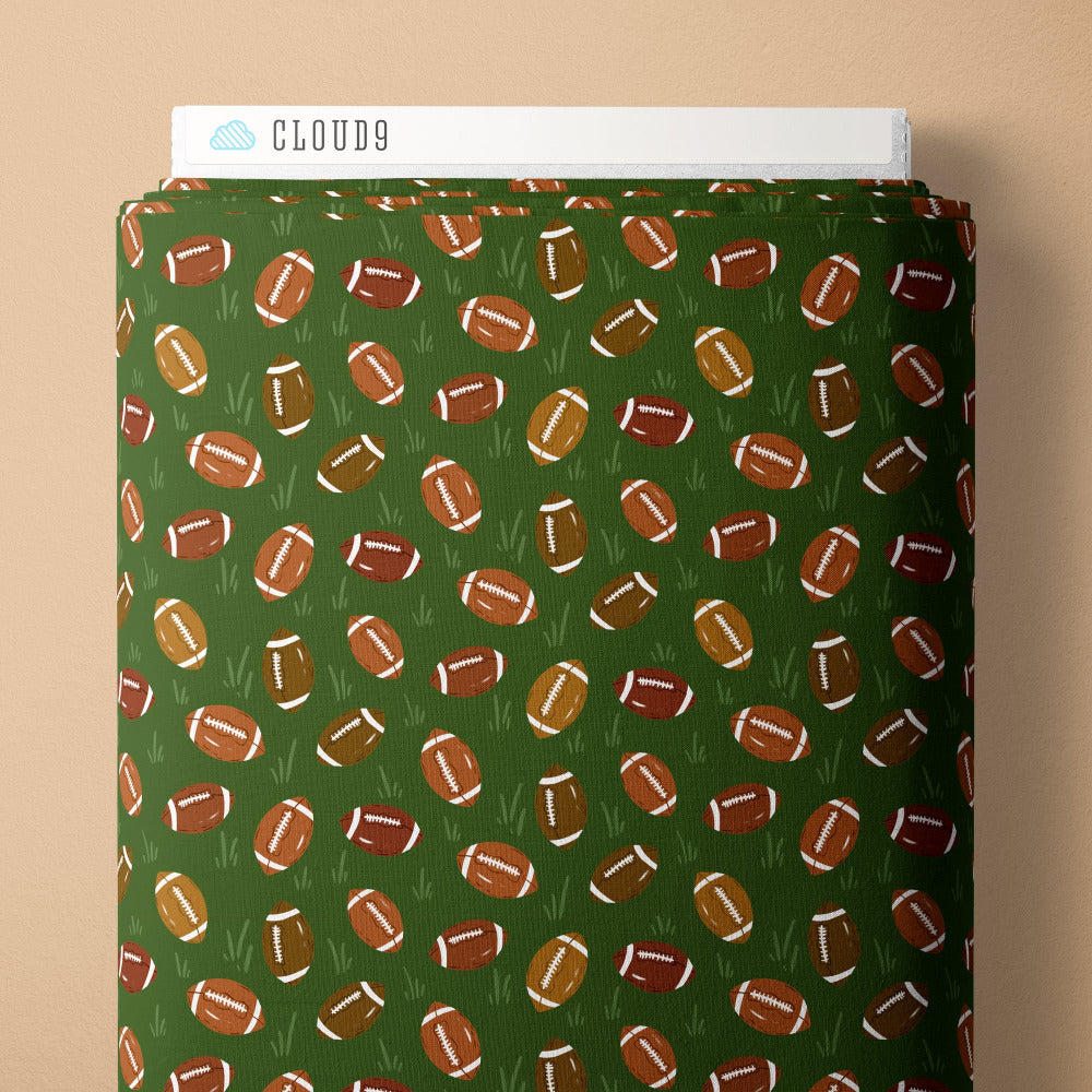 Pattern of footballs on a green background fabric