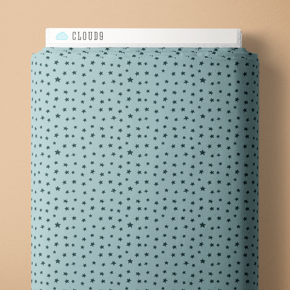 Pattern of small blue stars on a light blue background fabric