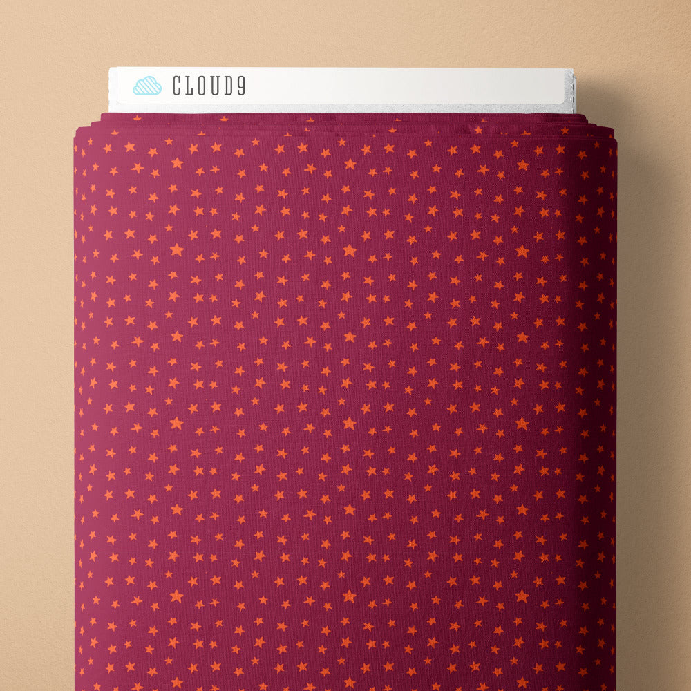 Pattern of small orange stars on a purple background fabric