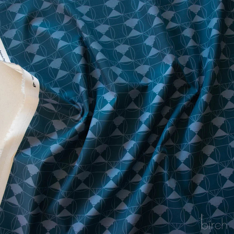 Patterned fabric with a blue geometric design on a medium dark blue background