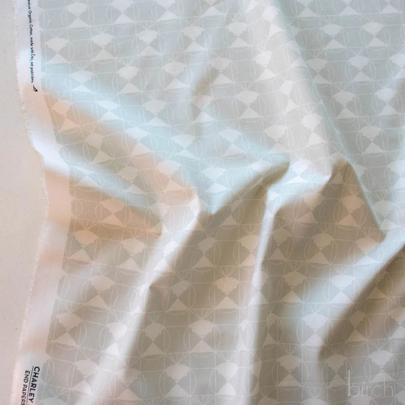 Patterned fabric with a white geometric design on a light gray background