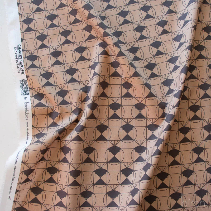 Patterned fabric with a brown geometric design on a tan brown background