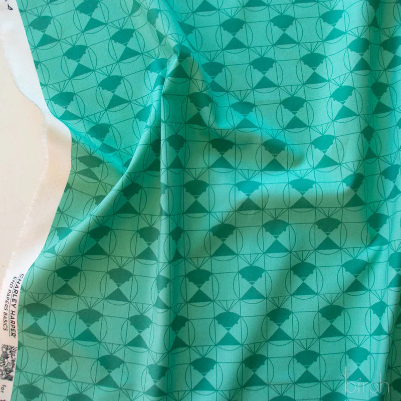 Patterned fabric with a green geometric design on a lighter green background