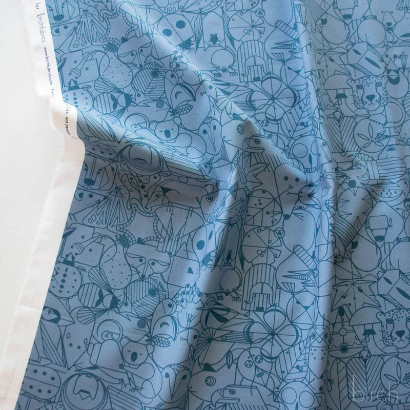 Pattern of various animal line art illustrations in dark blue on a blue background fabric