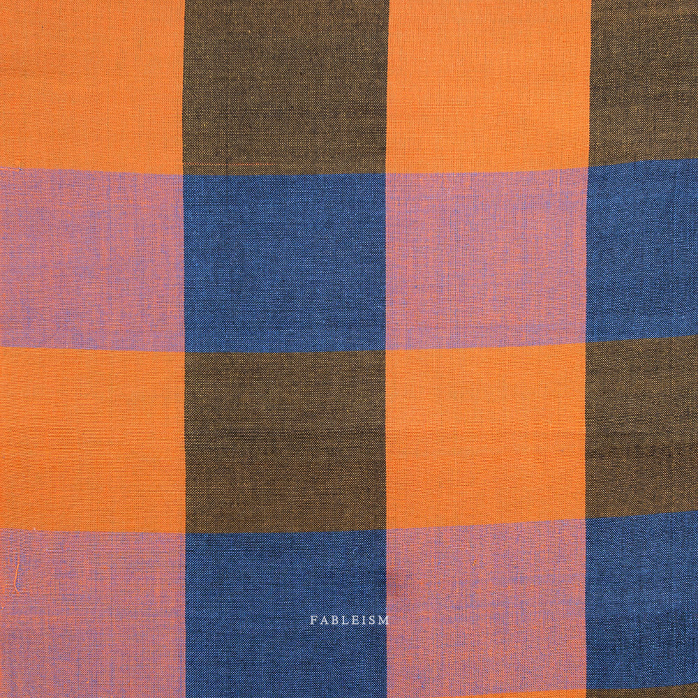 Checkered fabric with orange, blue, and brown squares on a white background, featuring the brand 'Fableism'.