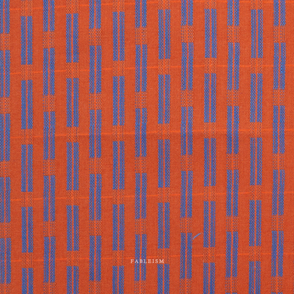 Orange fabric with blue pattern and 'Fableism' branding on a white background
