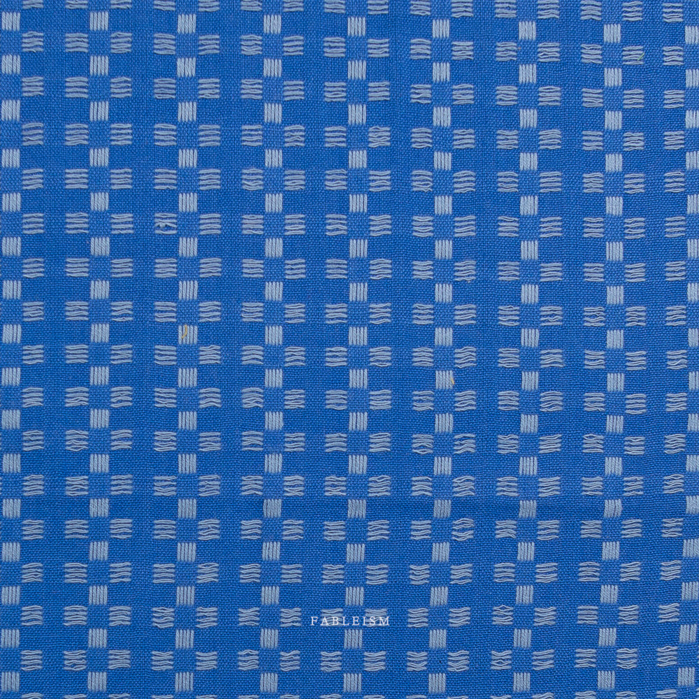 Blue fabric with a subtle pattern on a white background