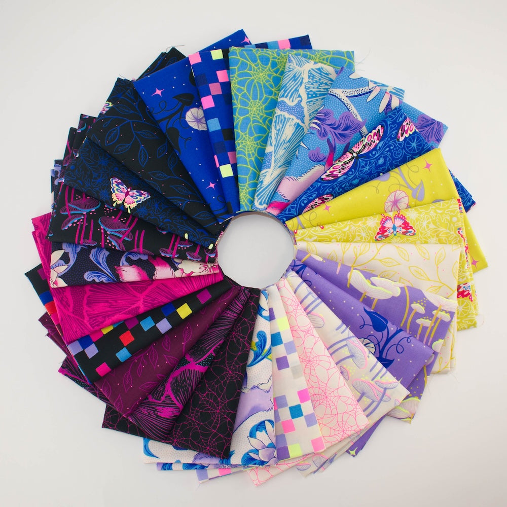 Colorful fabric fat quarters arranged in a circular pattern on a white background