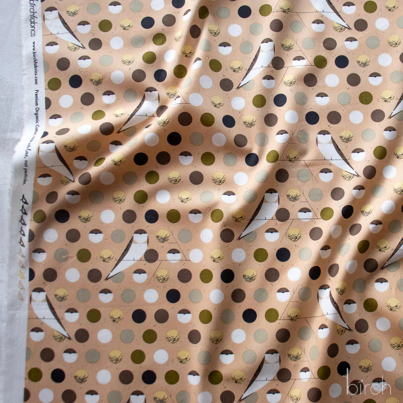 Patterned fabric with birds, dots, and geometric shapes on a beige background