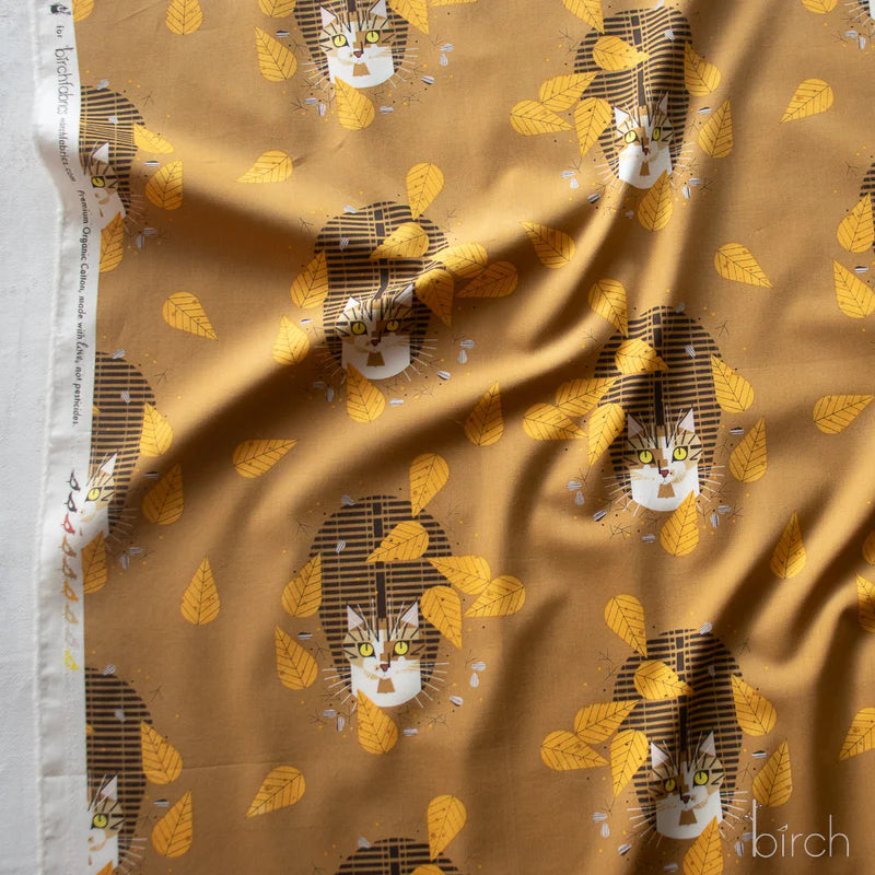 Fabric with cat and leaf pattern on a brown background