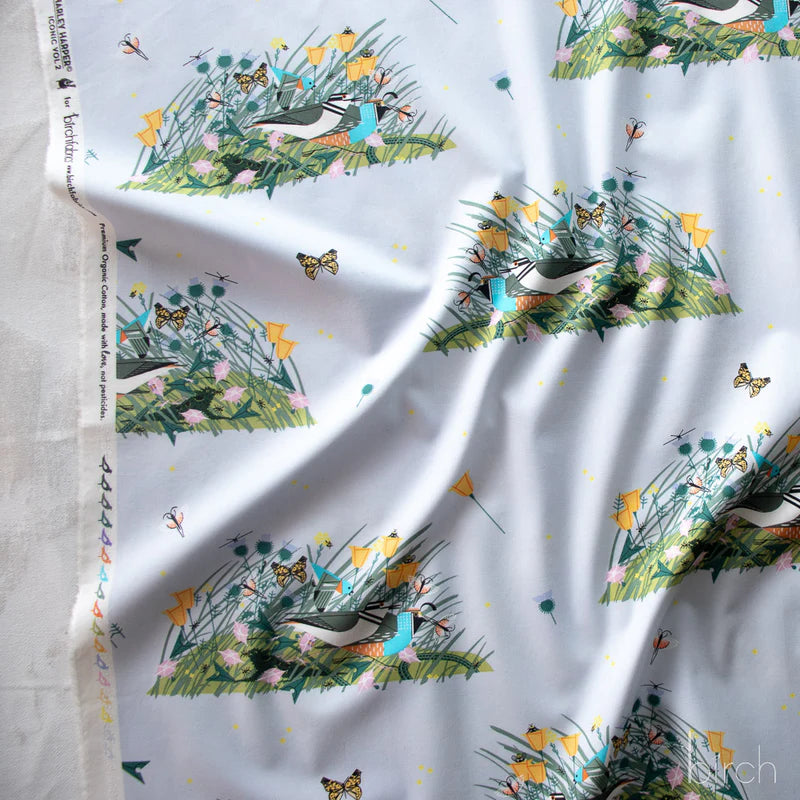 Fabric with birds, flowers, and butterflies on a light blue background