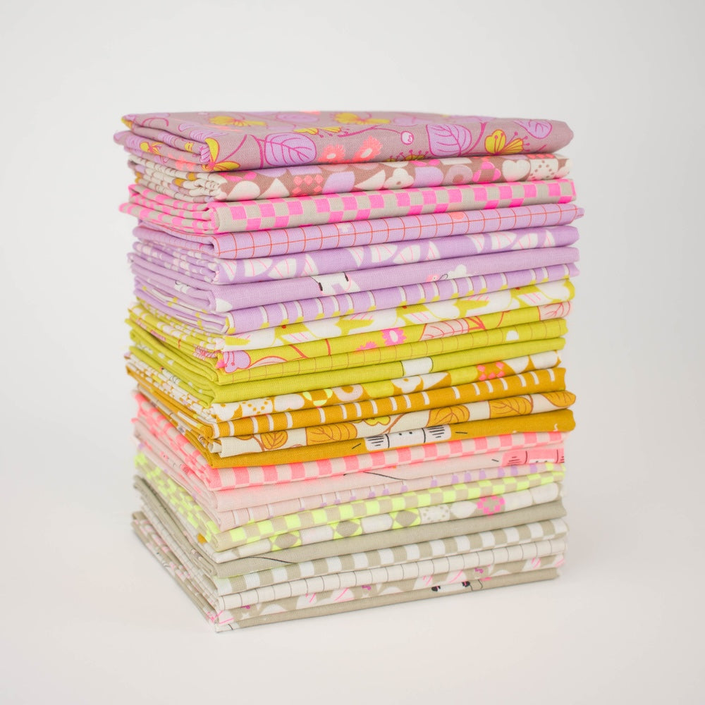 A circular arrangement of folded fabric swatches in pastel and bright colors, including pink, yellow, lavender, beige, and white, with floral and checkered patterns, displayed on a white background.