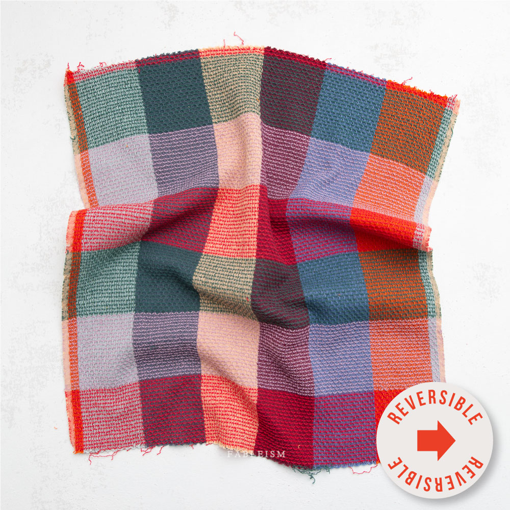 Multicolored checkered fabric with Fableism brand name on a white background