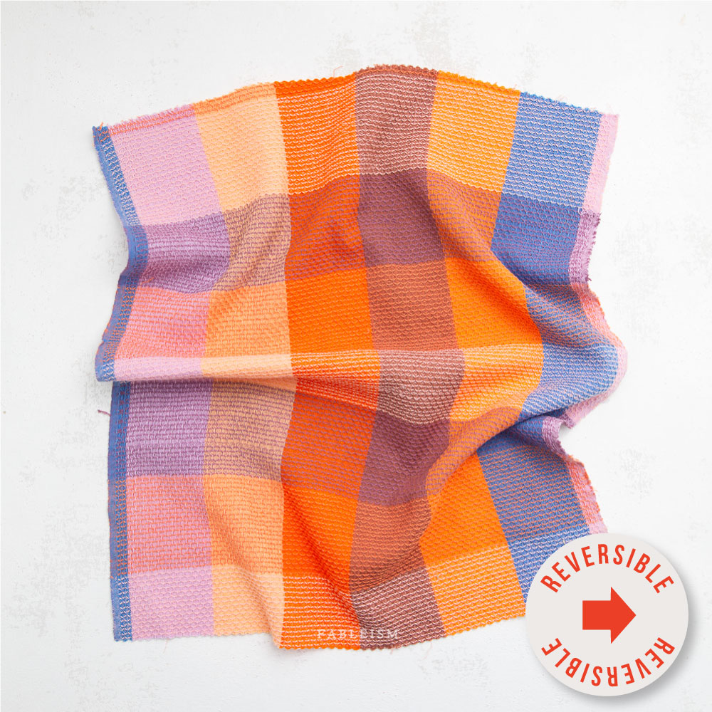 Close-up of a colorful checkered fabric with visible brand name, Fableism.