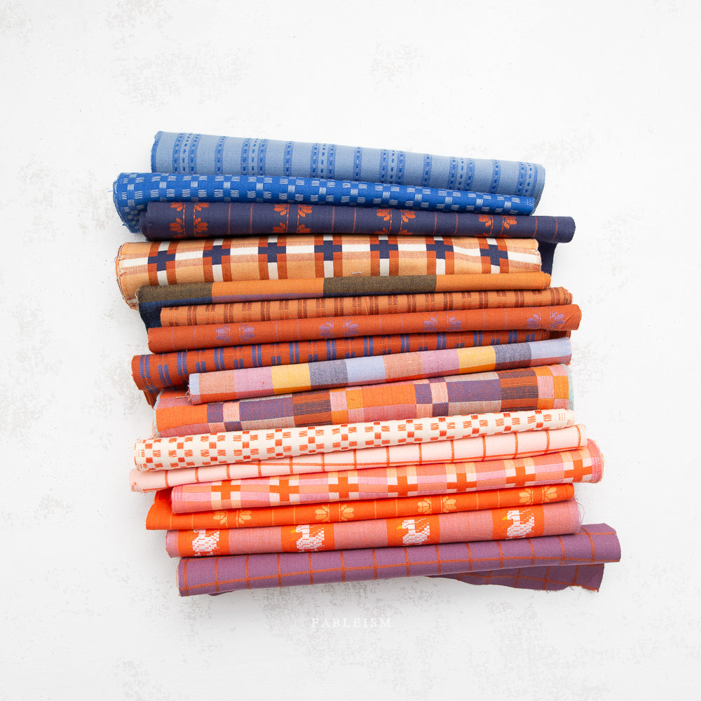 Stack of colorful folded fabrics on a white background